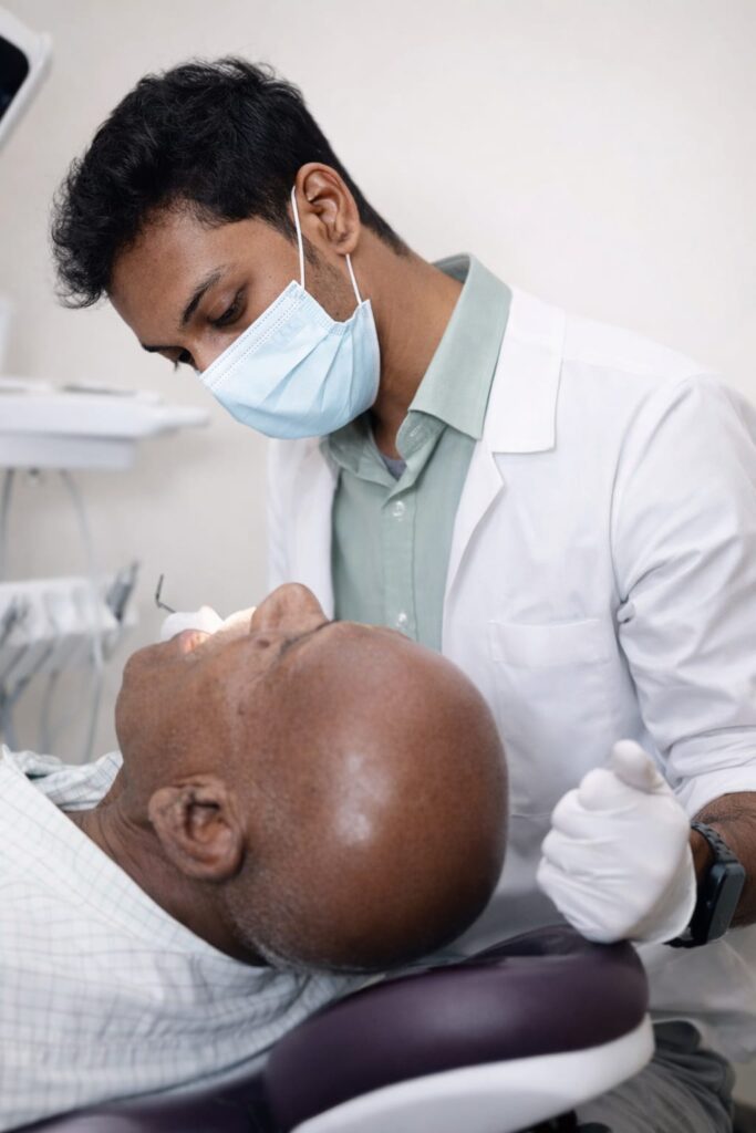 Dr. Shekar Subramanian examining a patient during a digital smile design and orthodontic consultation at Elegance Dental Clinic.